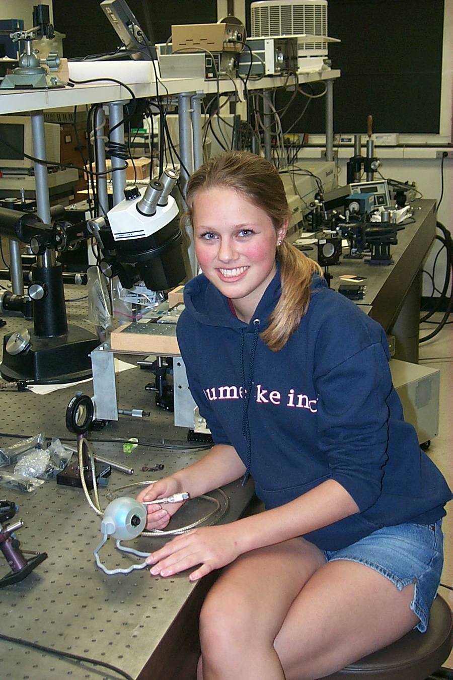 Noelle Stiles, then a high school student in the lab at the BMES ERC, displays the first-generation intraocular camera.