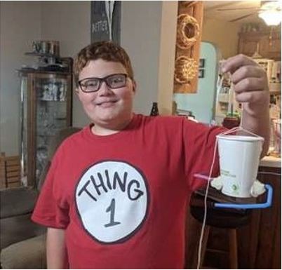 A student participant in Engineering Family Night proudly shows off his experiment.