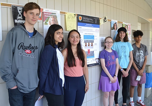 The BlankCubator high school student group with the poster for their design of a pre-term infant incubator that can keep working without electricity.